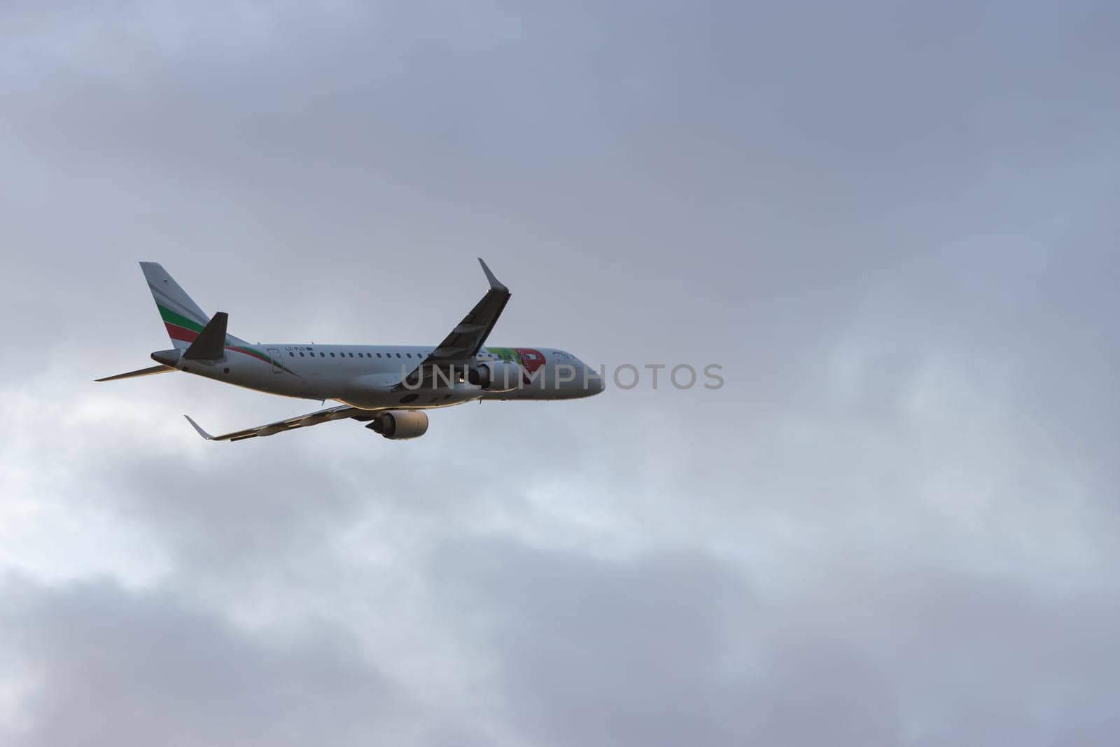 30 November 2022 PORTUGAL, LISBON: an AIRPORTUGAL passenger airplane flying in gray cloudy sky. Mid shot