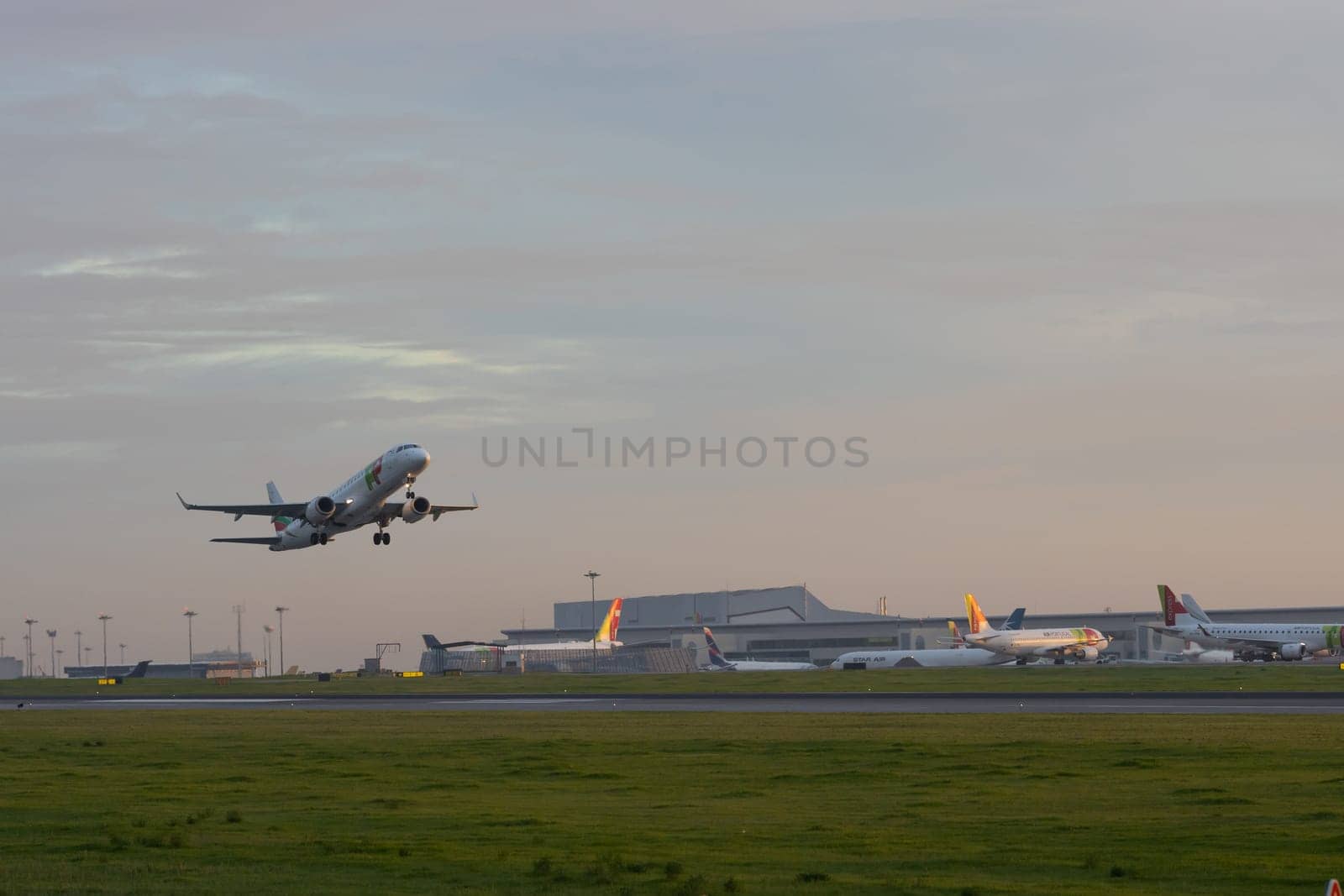 30 November 2022 PORTUGAL, LISBON: an AIRPORTUGAL passenger airplane takes off the runway at early sunset. Mid shot