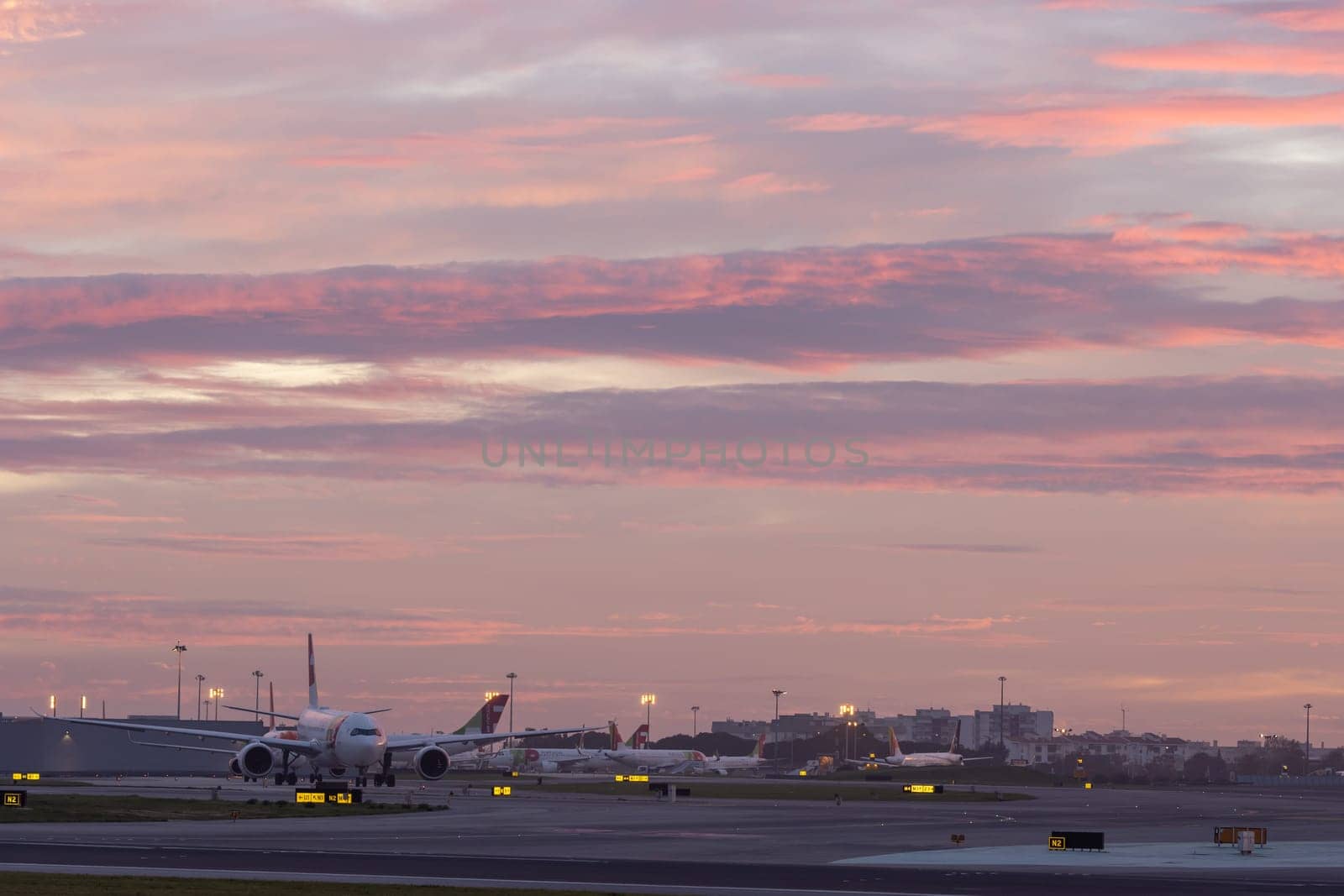 30 November 2022 PORTUGAL, LISBON: airplane field at purple sunset. Mid shot