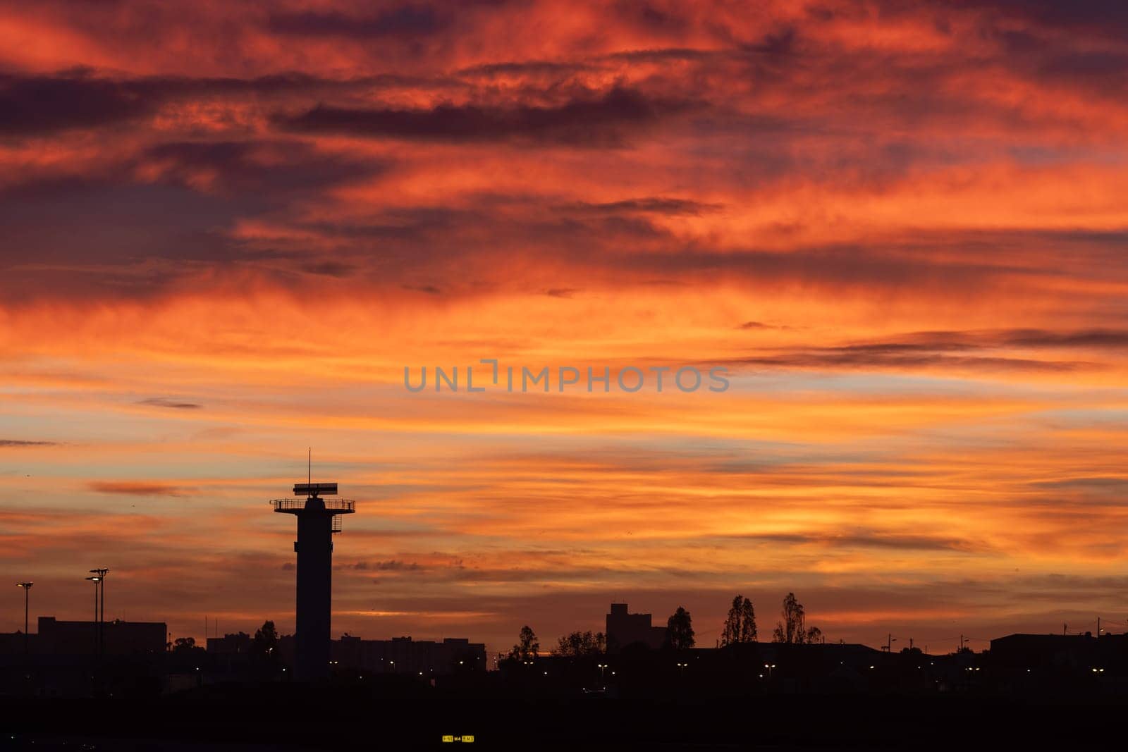 30 November 2022 PORTUGAL, LISBON: bright red sunset over the airport. Mid shot