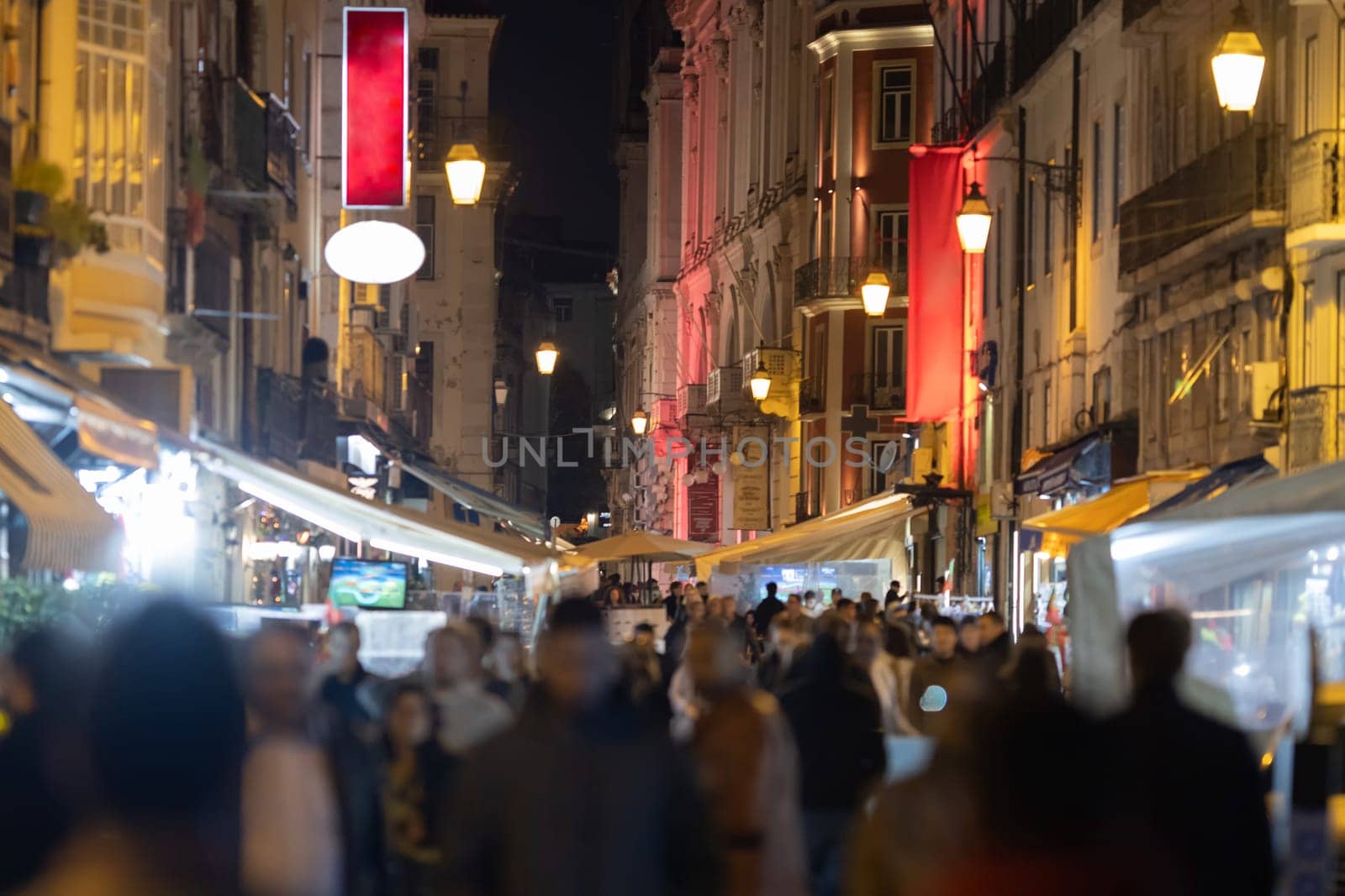 People walking in the narrow street of Lisbon. Mid shot