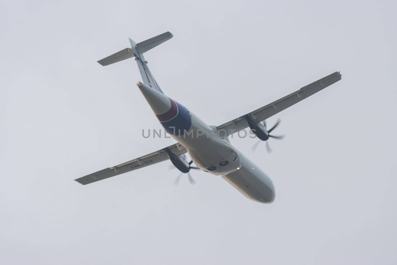30 November 2022 PORTUGAL, LISBON: A small plane with propellers on its wings takes off into the grey sky. Mid shot