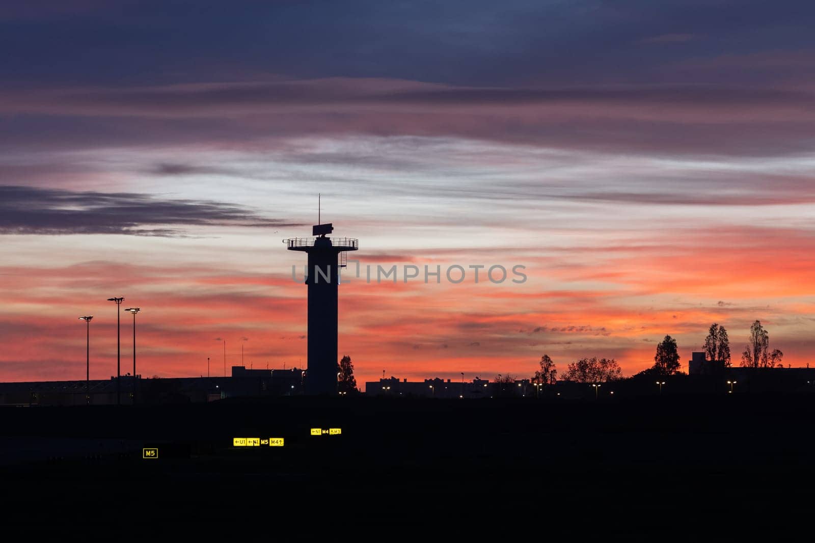 Observation tower at the airport at bright sunset. Mid shot