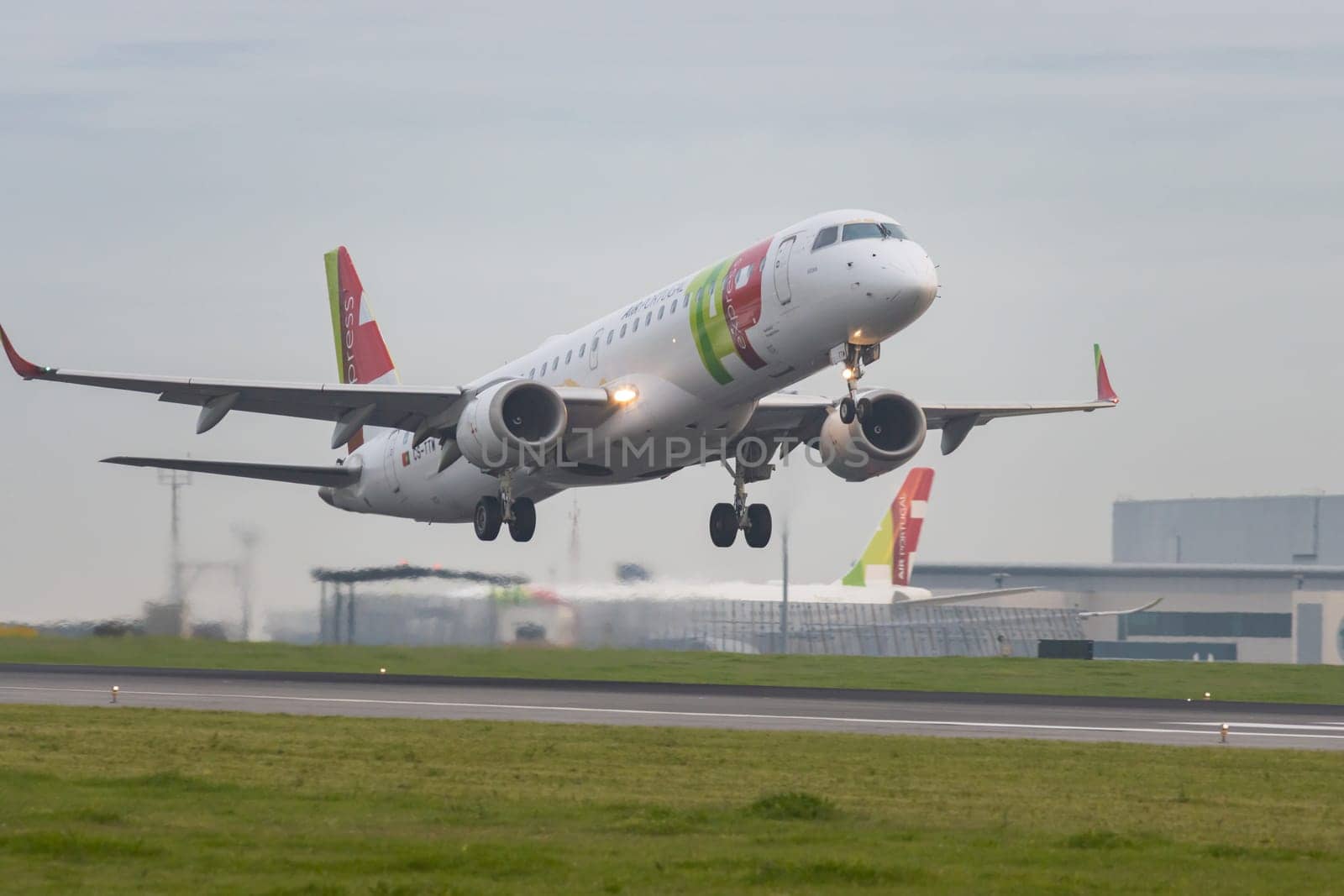 30 November 2022 PORTUGAL, LISBON: an AIRPORTUGAL airplane takes off the runway in grey cloudy weather. Mid shot
