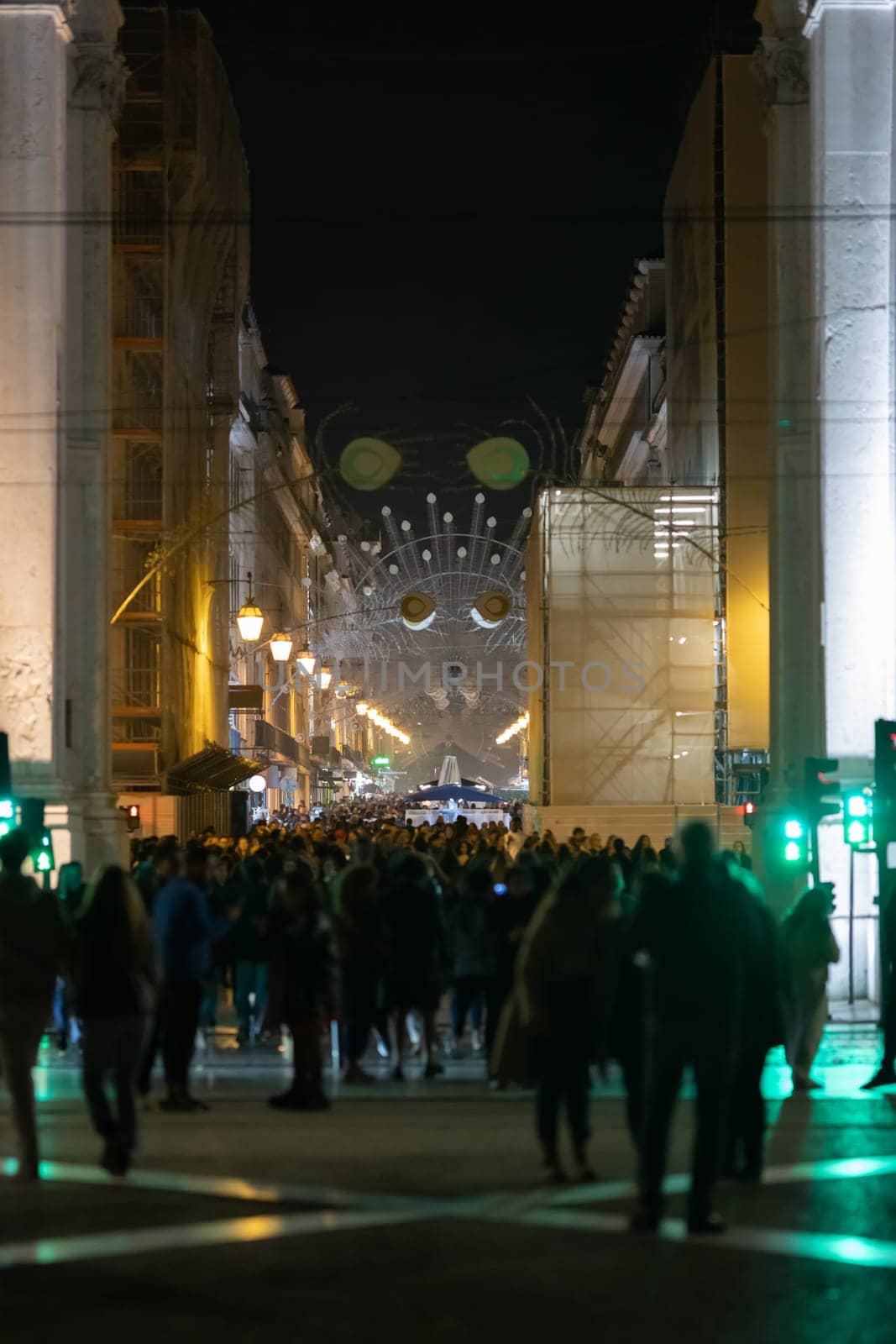People walk along lisbon's decorated main street. Mid shot