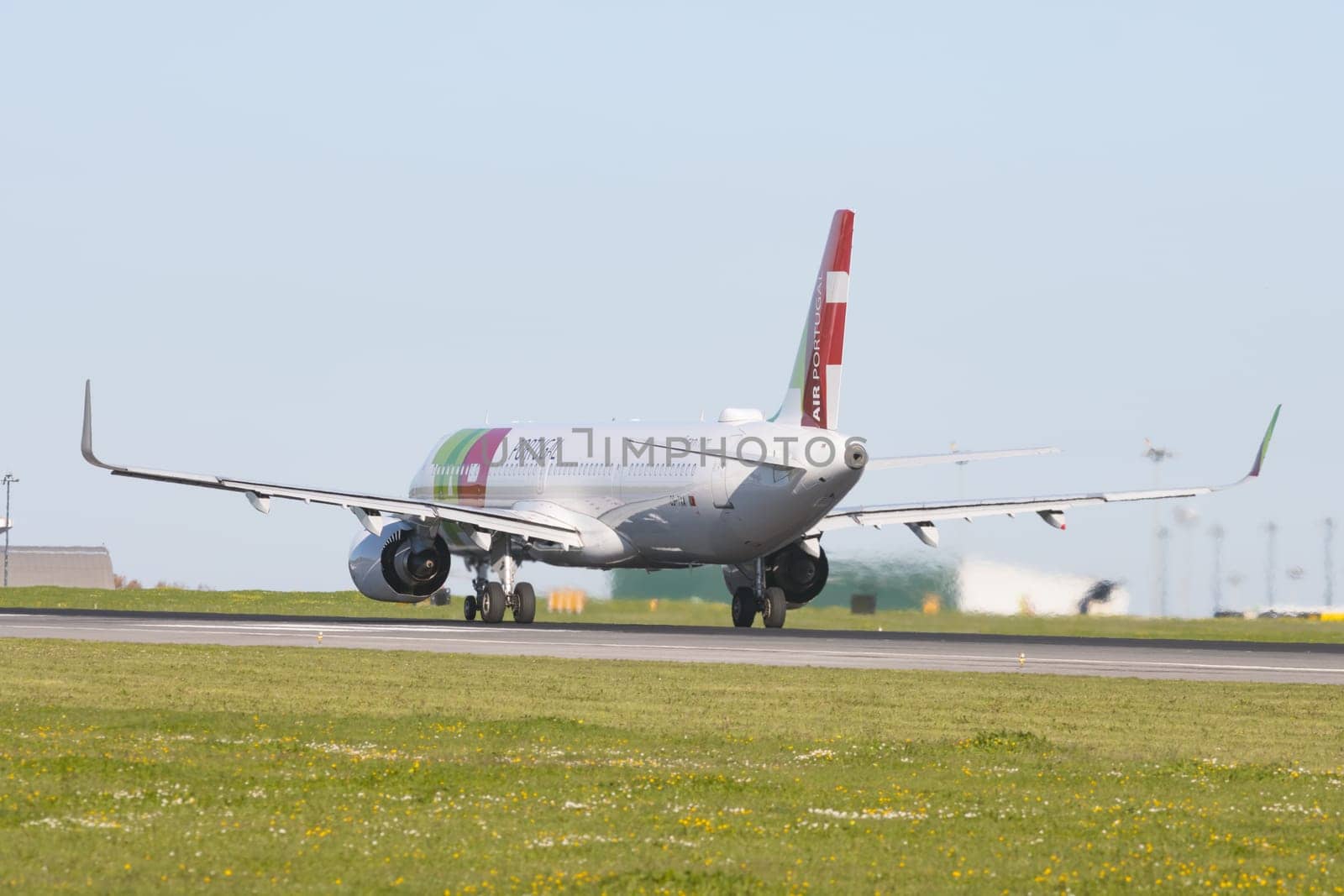 1 December 2022 PORTUGAL, LISBON: AIRPORTUGAL passenger plane rides down the runway on landing gear. Mid shot