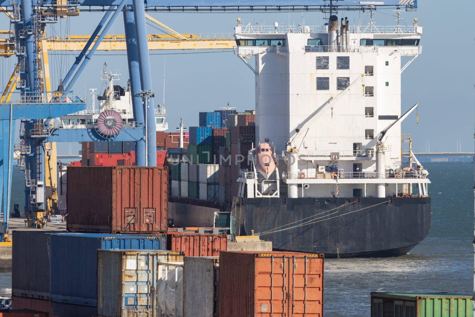 Industrial ship at the port with containers. Mid shot