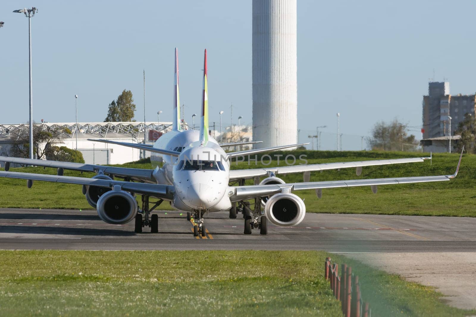 1 December 2022 PORTUGAL, LISBON: passenger planes stand in a row on the airport field. Mid shot