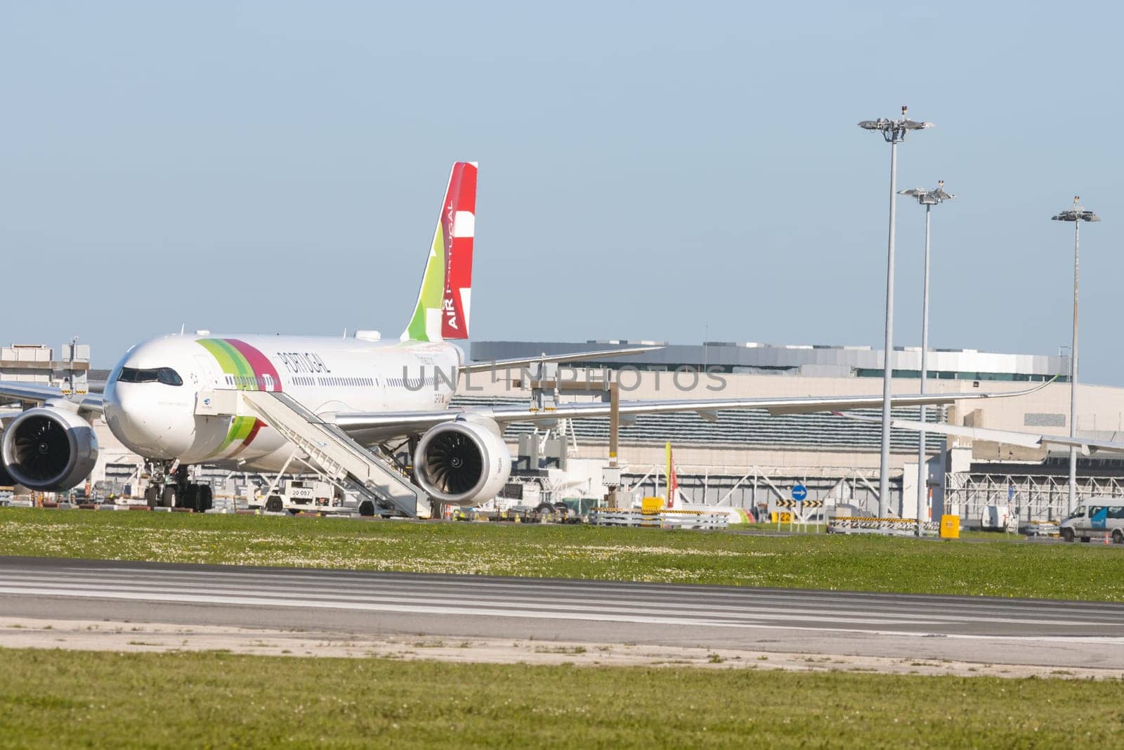1 December 2022 PORTUGAL, LISBON: large passenger aircraft on the field by the airport. Mid shot