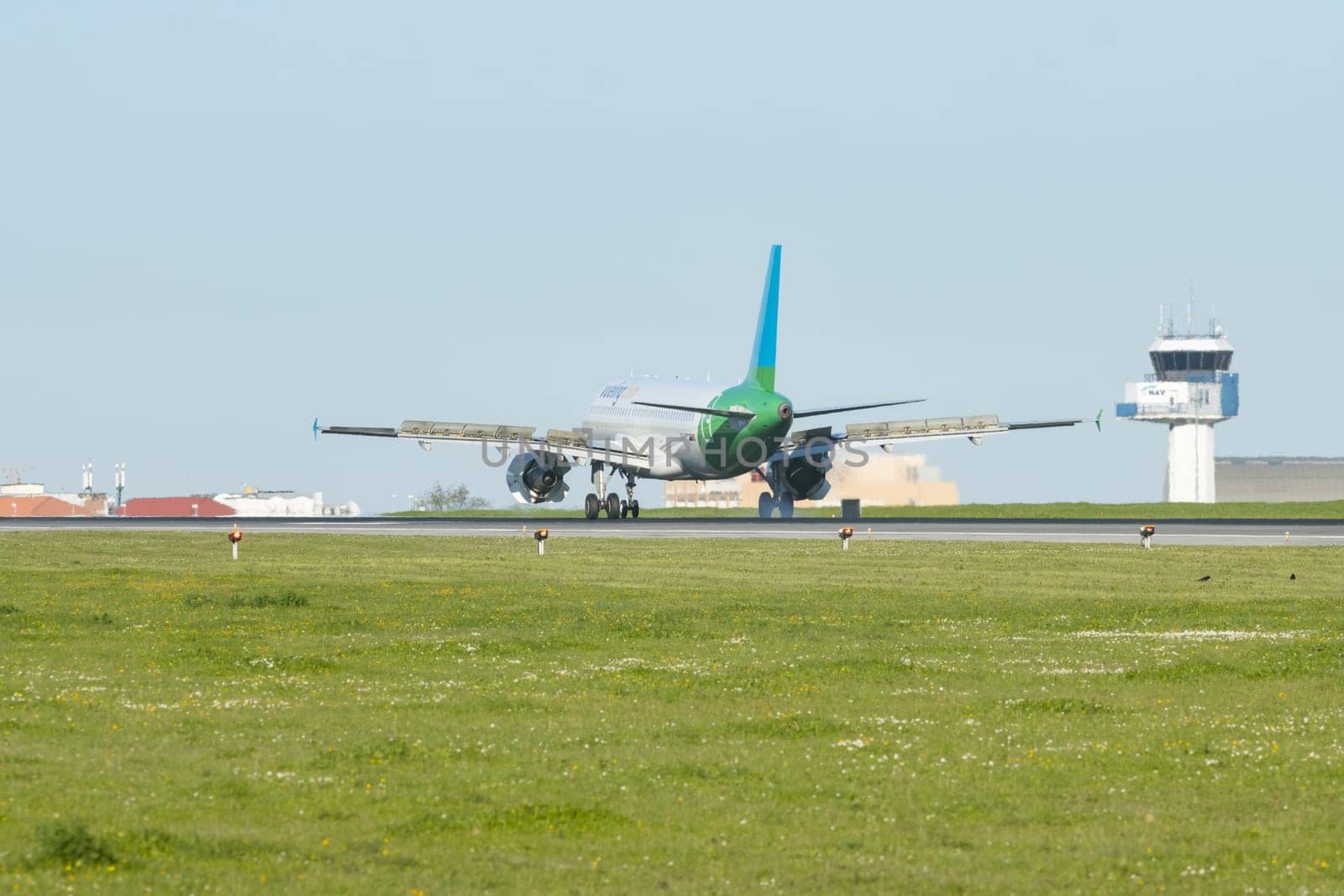 1 December 2022 PORTUGAL, LISBON: airplane with VUELING dot COM sign on the corpus landed on the runway. Mid shot