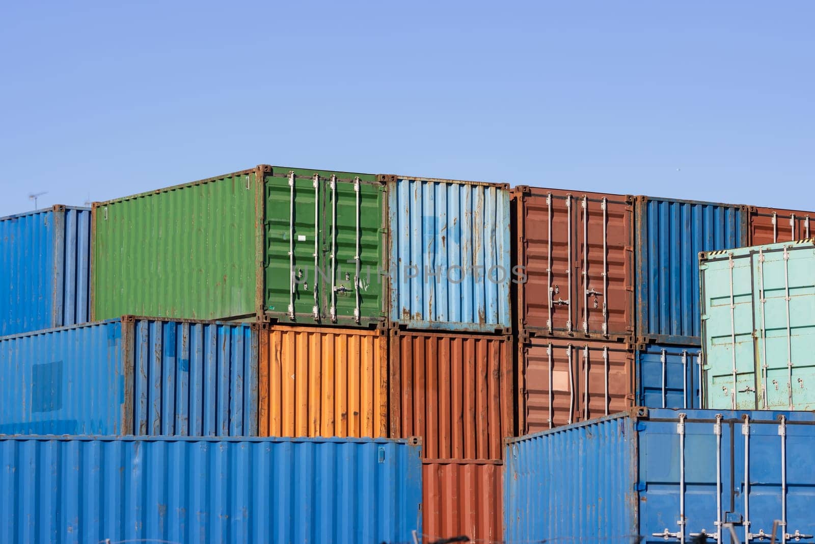 Flatly exposed cargo containers against the blue sky. Mid shot