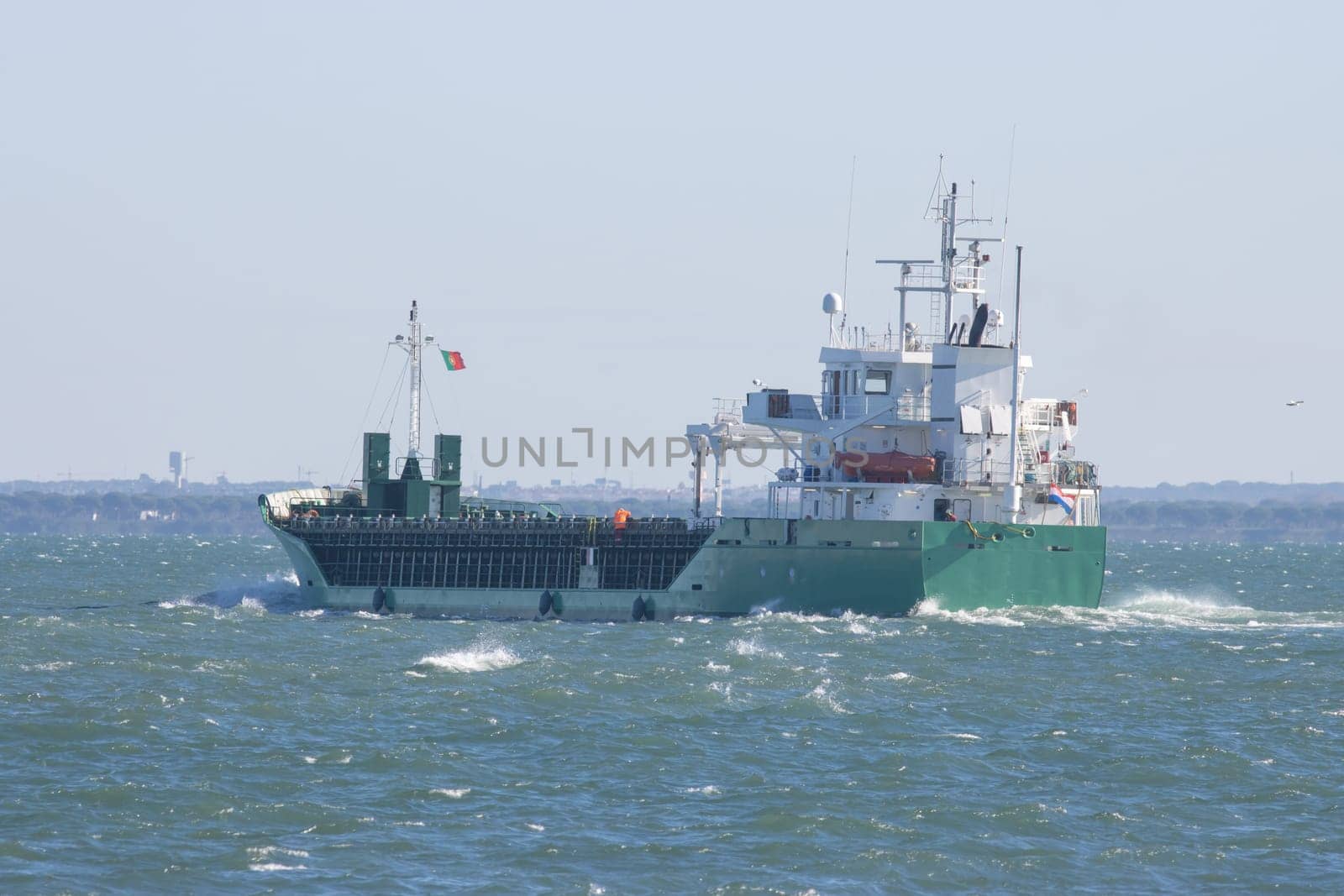 A big portuguese cargo ship sails the sea. Mid shot
