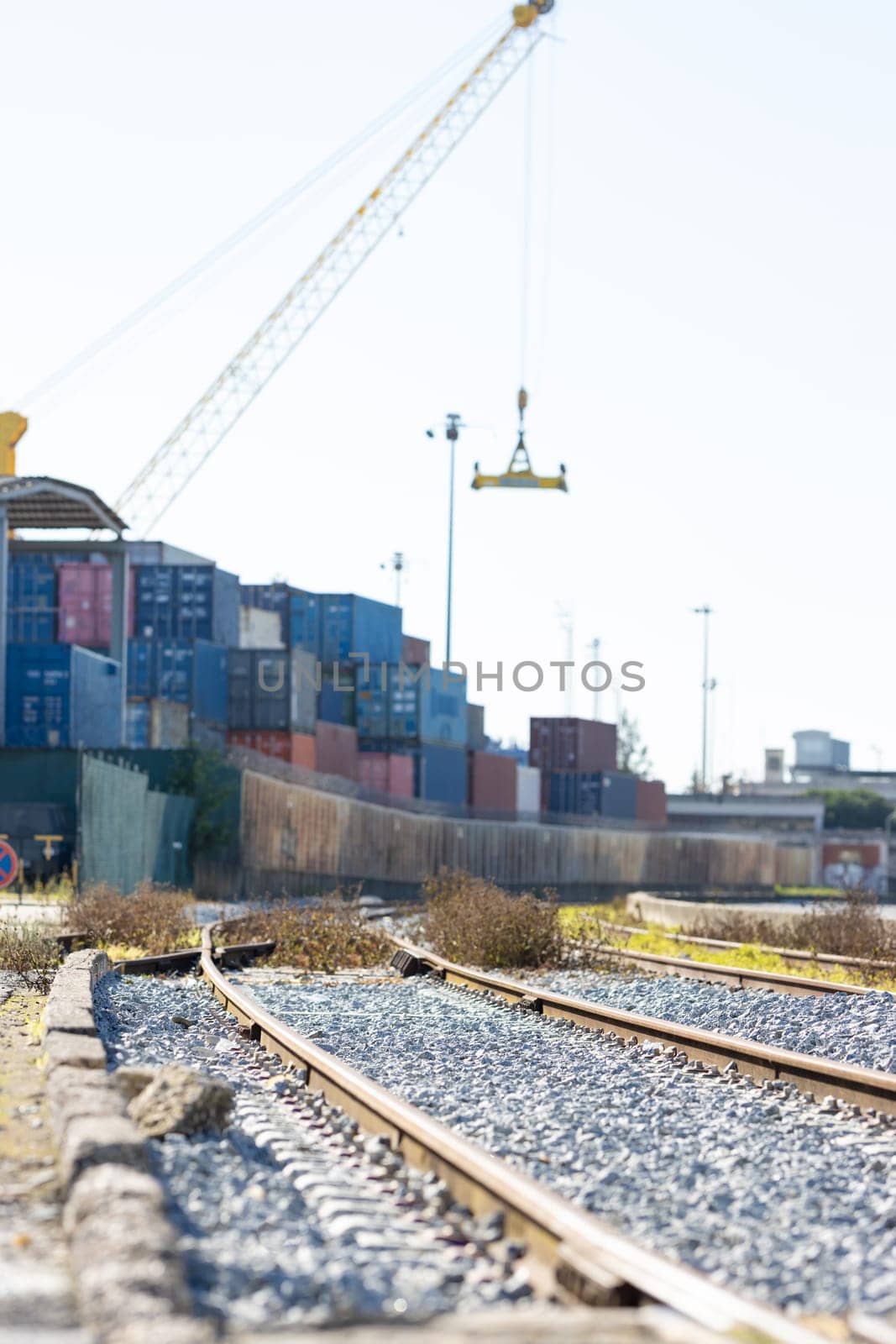 Railways near the warehouse with a bunch of containers in the open air. Vertical shot