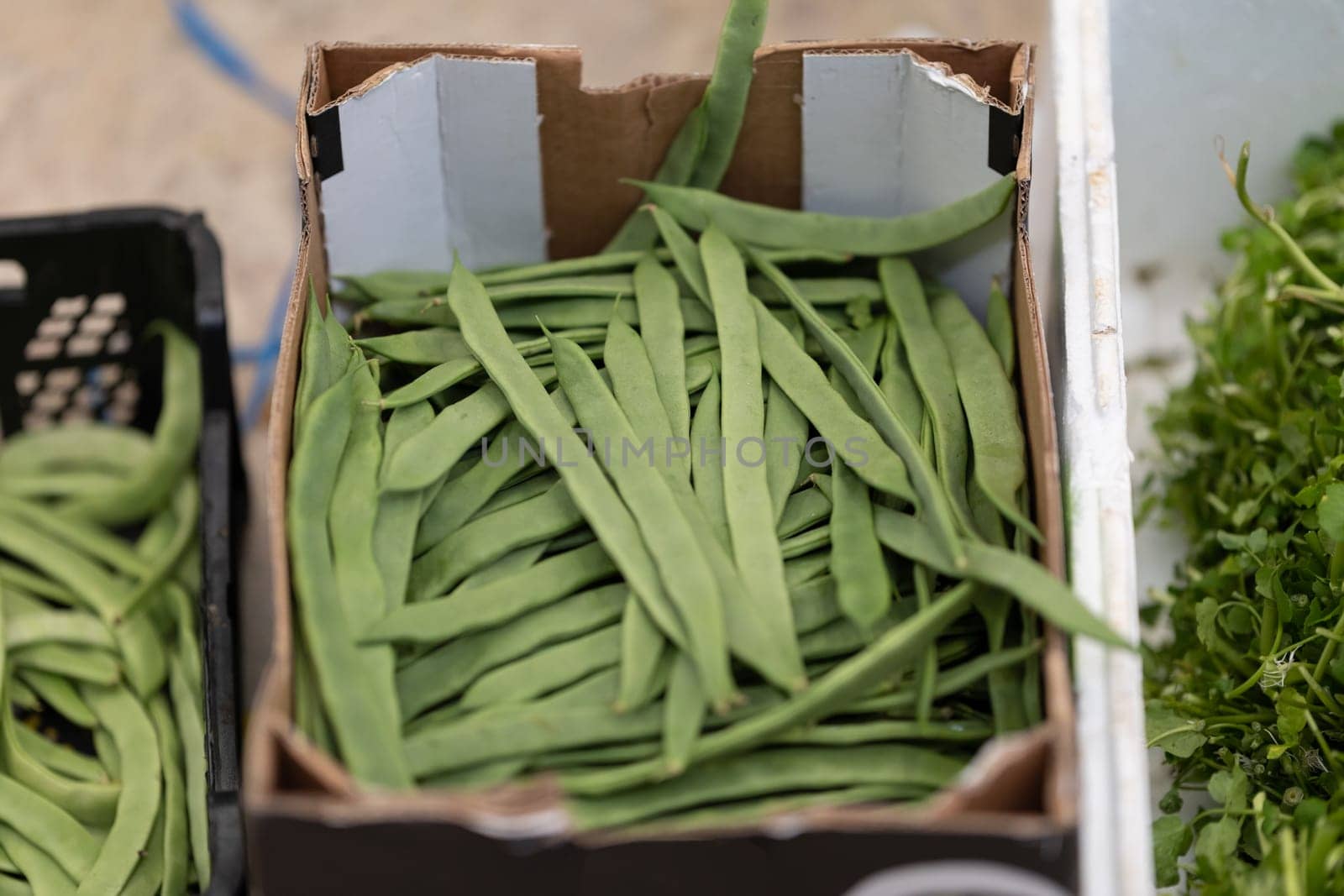 Fresh green string beans in a box at the market. Mid shot