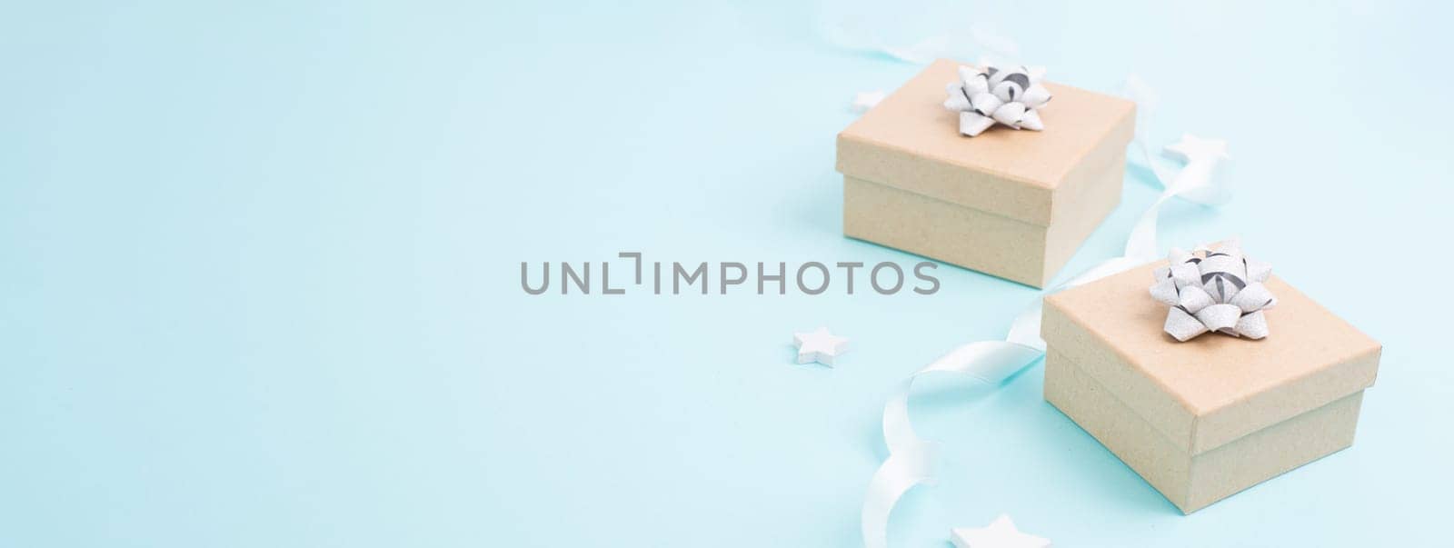 Christmas holiday greeting card with little gift boxes, stars and fir branches, blue background