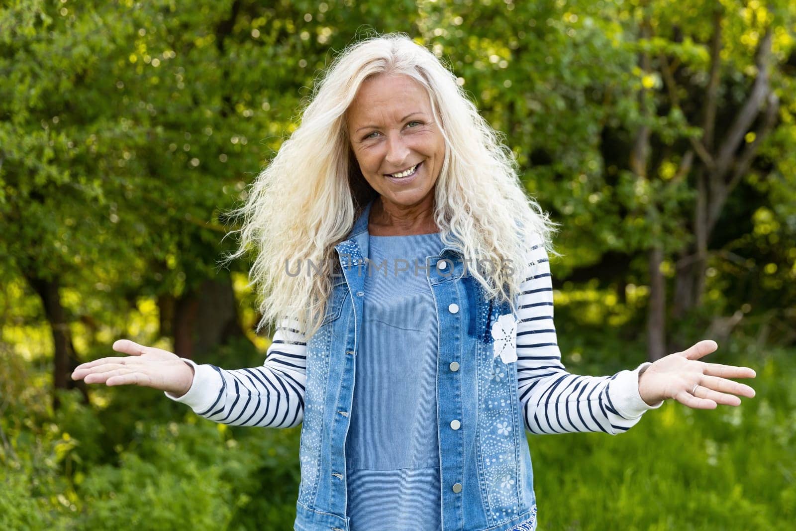 Happy caucasian woman with long hair raise her arms