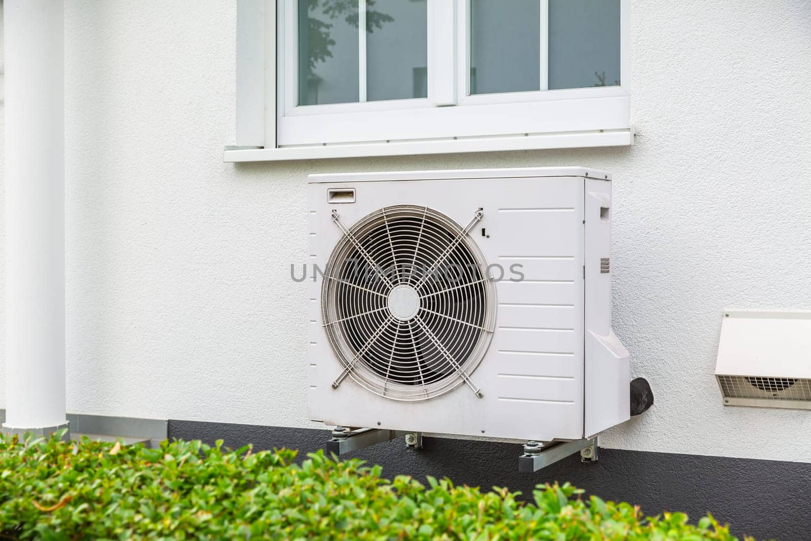 Air source heat pumps installed outside of city house, green renewable energy concept of heat pump