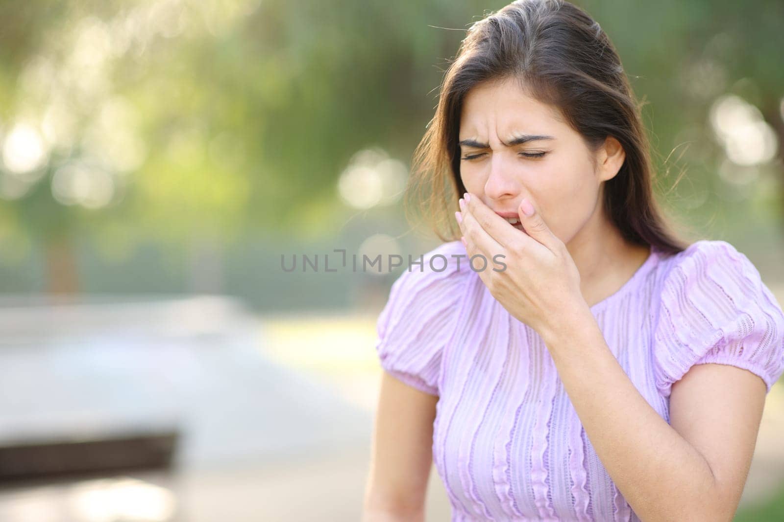 Woman coughing walking in a park