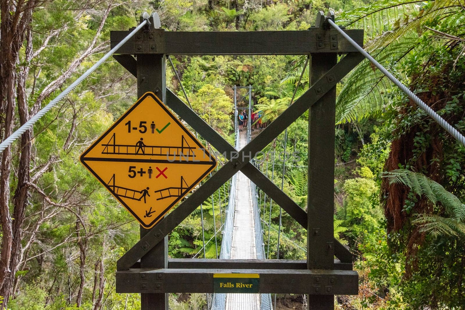 Warning signs about a suspension footbridge in Abel Tasman Cost Track, New Zealand