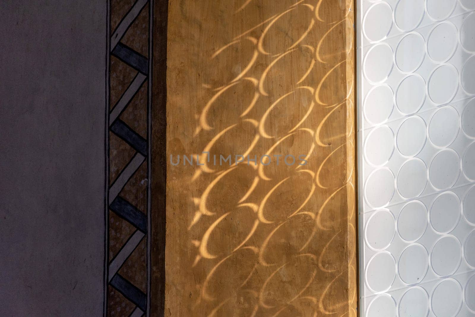 Sun shining through circled frosted glass and casting shadow on the wall
