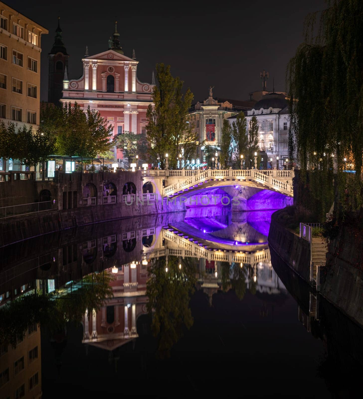 Famous three bridges at the Preseren square in the center of Ljubljana colorfully illuminated at night, Slovenia