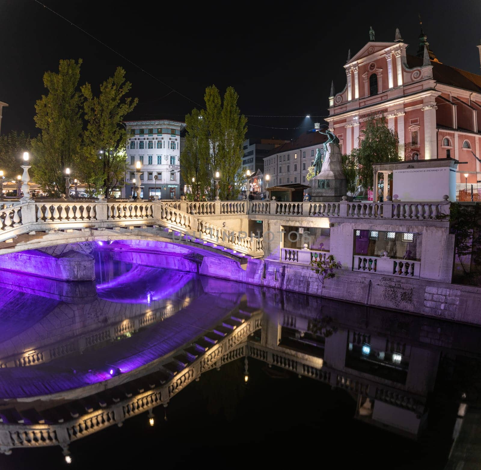 Famous three bridges at the Preseren square in the center of Ljubljana colorfully illuminated at night, Slovenia