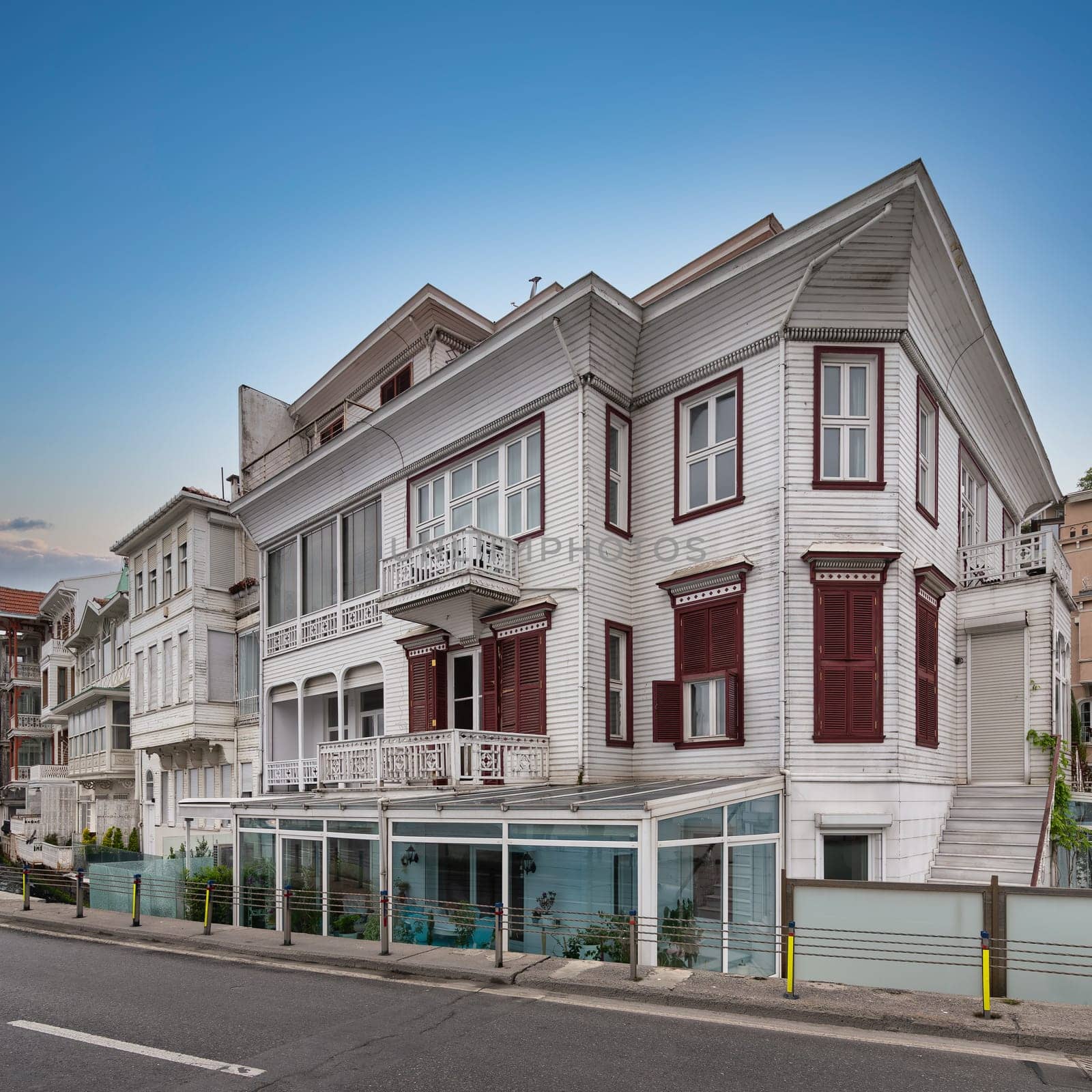 White wooden traditional residential buildings overlooking Bosphorus strait, in Arnavutkoy neighborhood, Besiktas district, Istanbul, Turkiye, in a sunny spring day