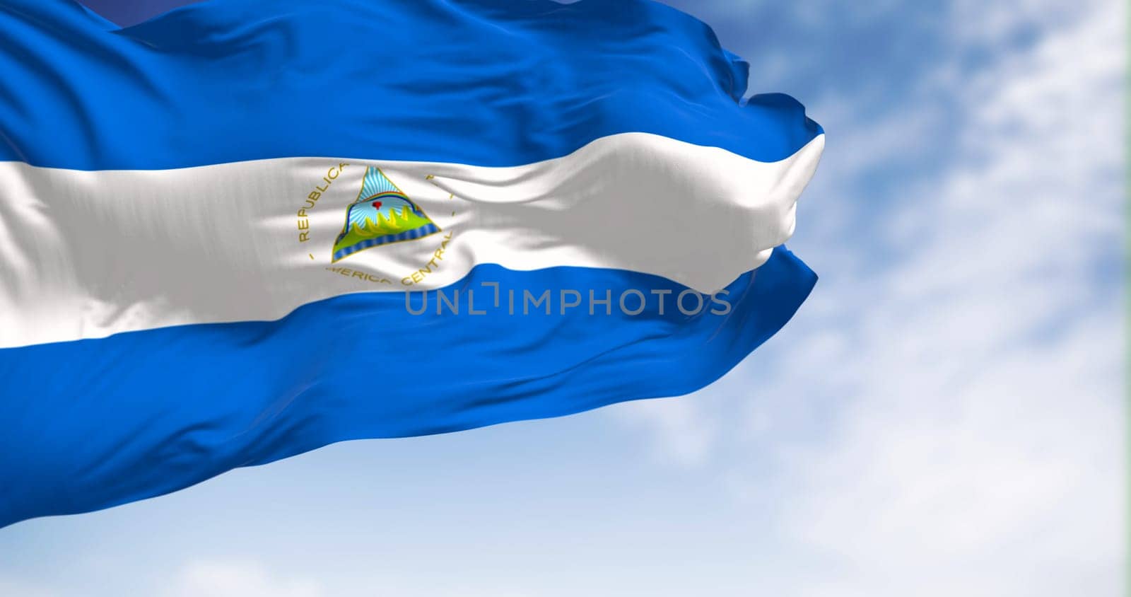 Nicaragua national flag waving on a clear day. Blue, white, and blue with a national coat of arms. 3d illustration render. Fluttering fabric.