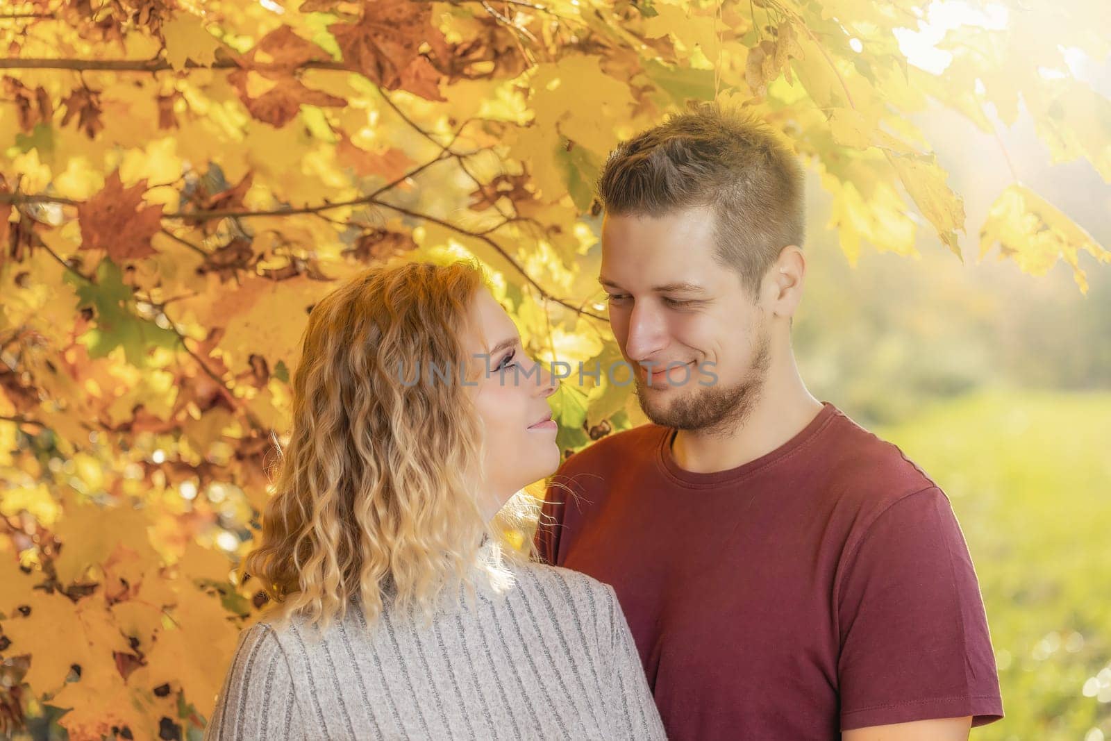 Young couple in love is posing in an autumn park. Horizontally.