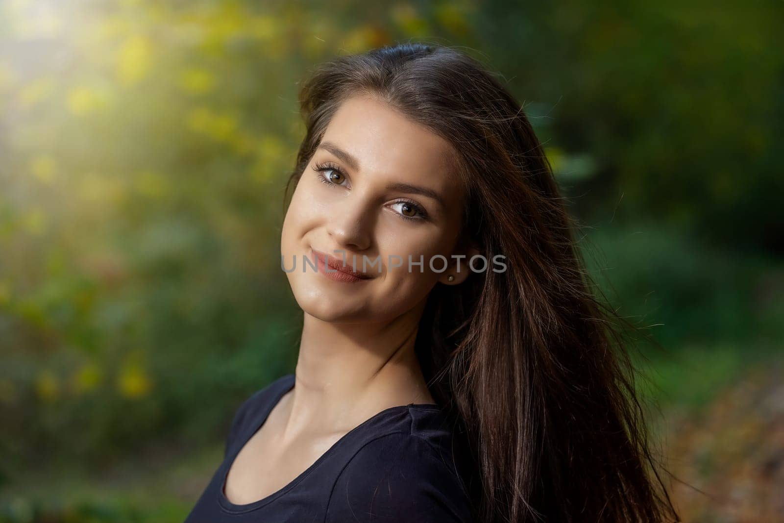 Portrait of attractive young brunette woman posing outdoors in autumn. Horizontally.