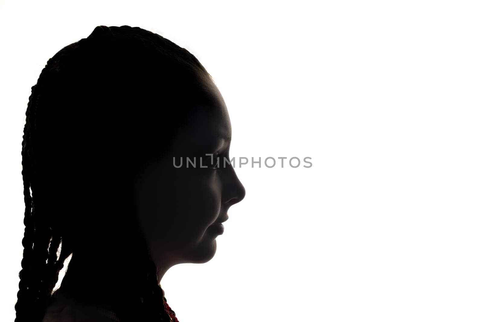 The girl portrait profile in silhouette shadow on studio. White background. Horizontally.