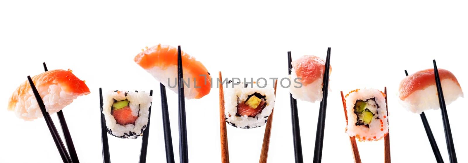Creative sushi rolls on bamboo chopstick isolated on white background. Japanese luxury cuisine menu. Asian restaurant menu design. Mix of sushi pieces with salmon, tuna fish, avocado and rice.