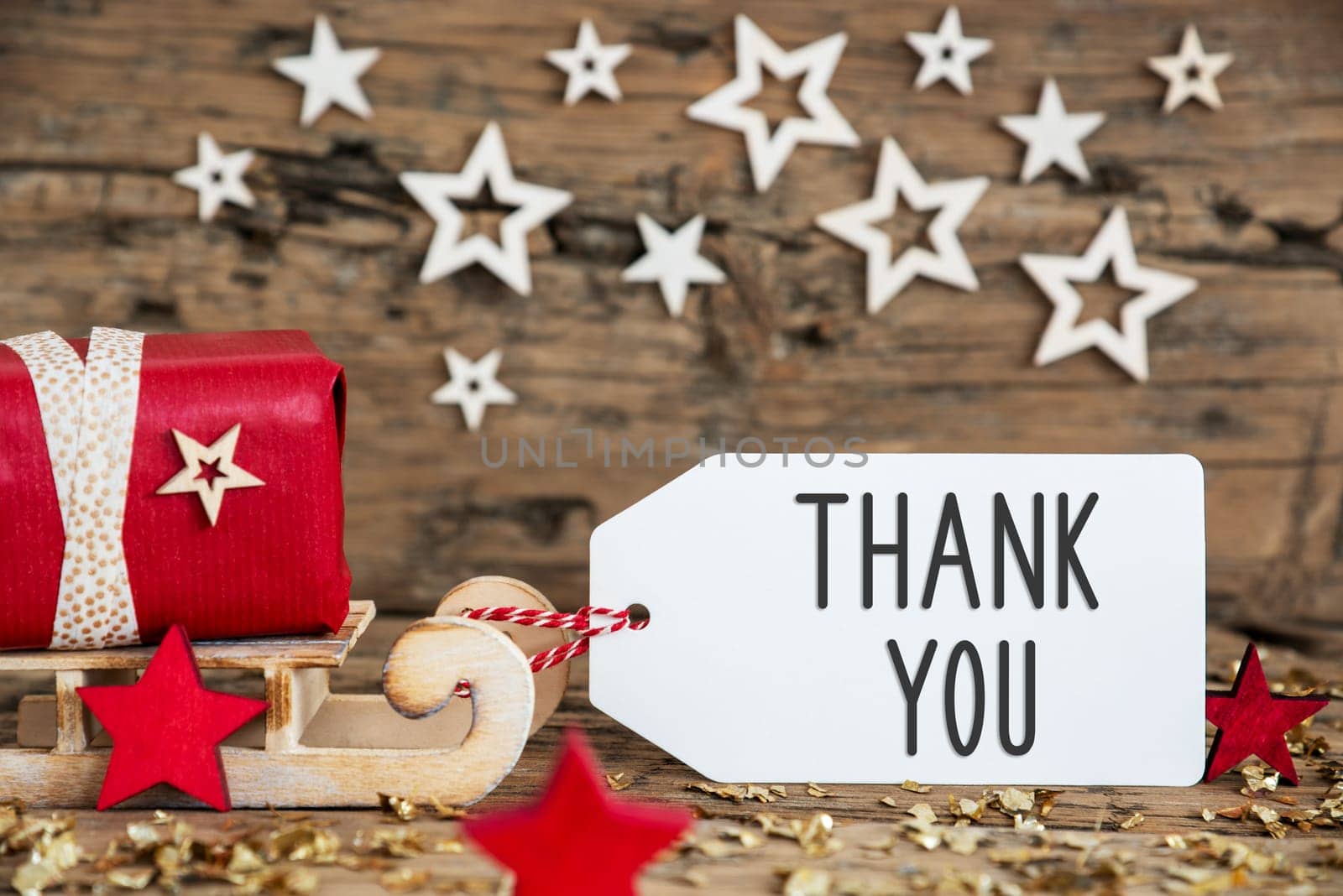 Wooden Sled With Red Gift And Rustic Christmas Background With Label With Text Thank You