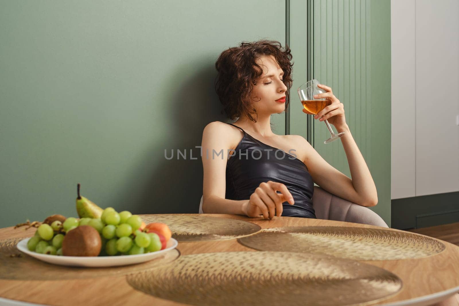 Elegant woman inhales aroma of wine she brought back from her trip
