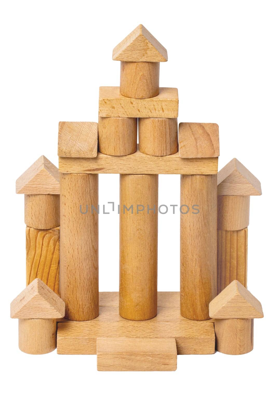 Wooden isolated house. Wooden toy castle constructed of cubes, cylinders, triangles and other shapes made of beech wood. Wooden toy blocks. Macro.
