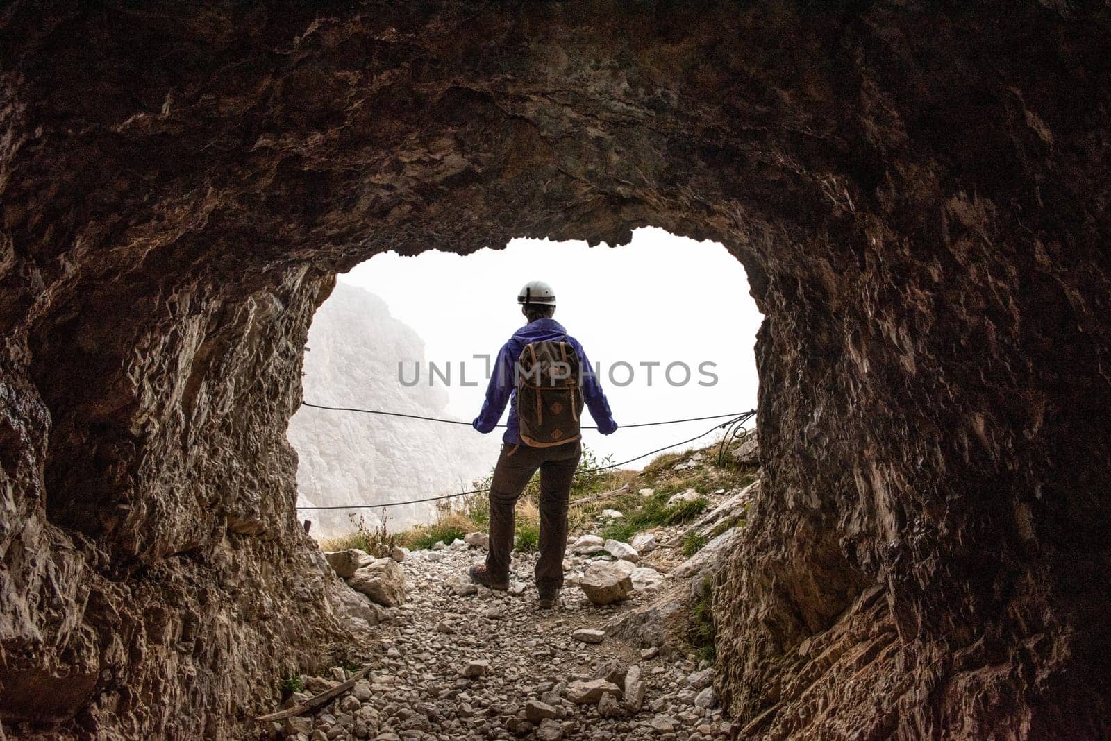 A hiker enjoying the view out of an old military tunnel at Mount Lagazuoi, autonomous province of South Tirol