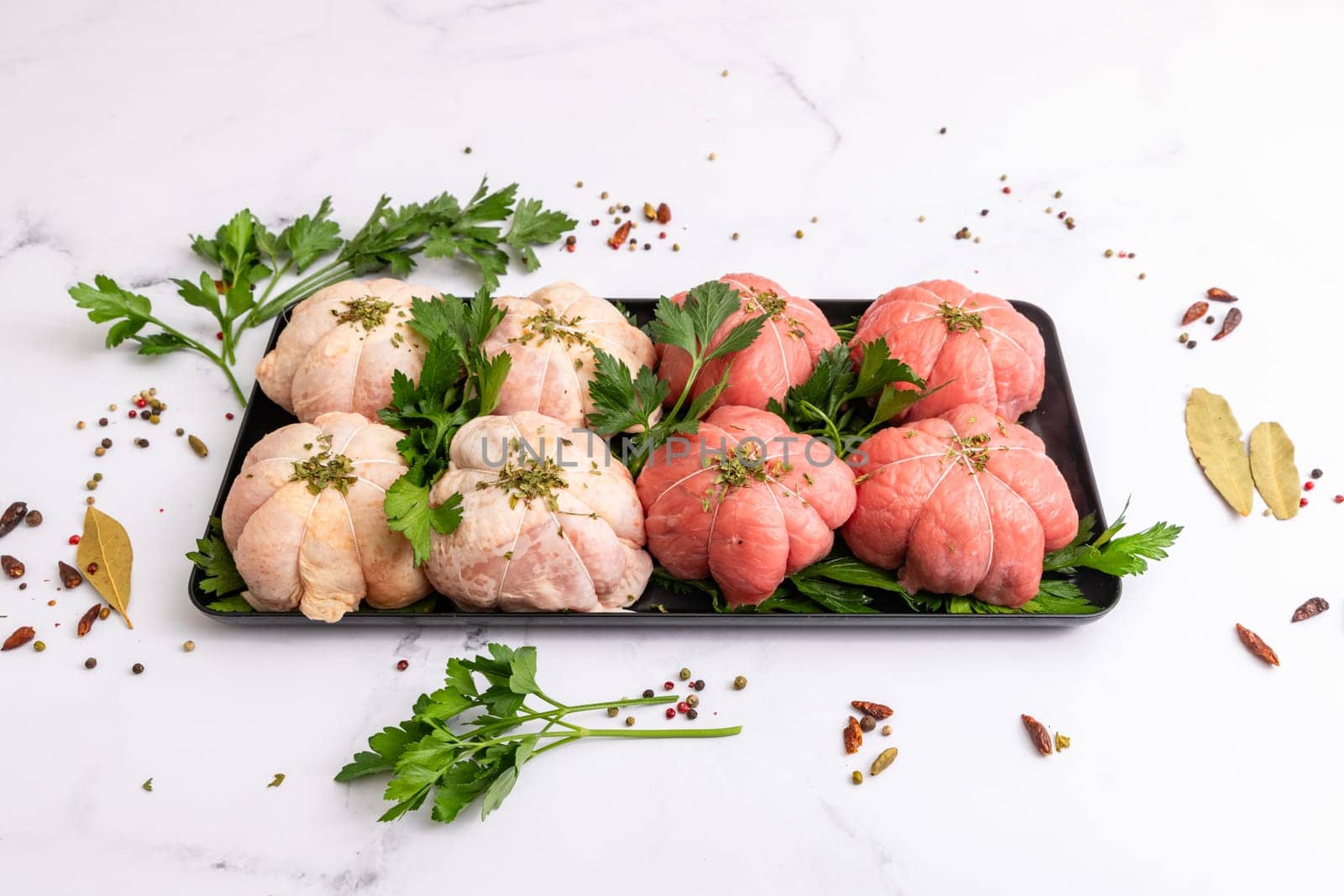 Pockets of raw beef and chicken with parsley on a platter
