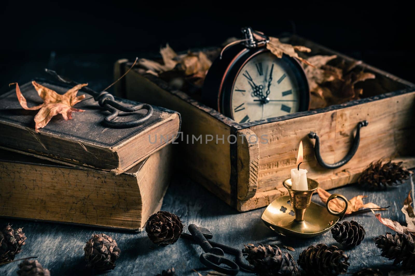 Vintage still life with  antique  books, clock and candle. Halloween and occult concept.