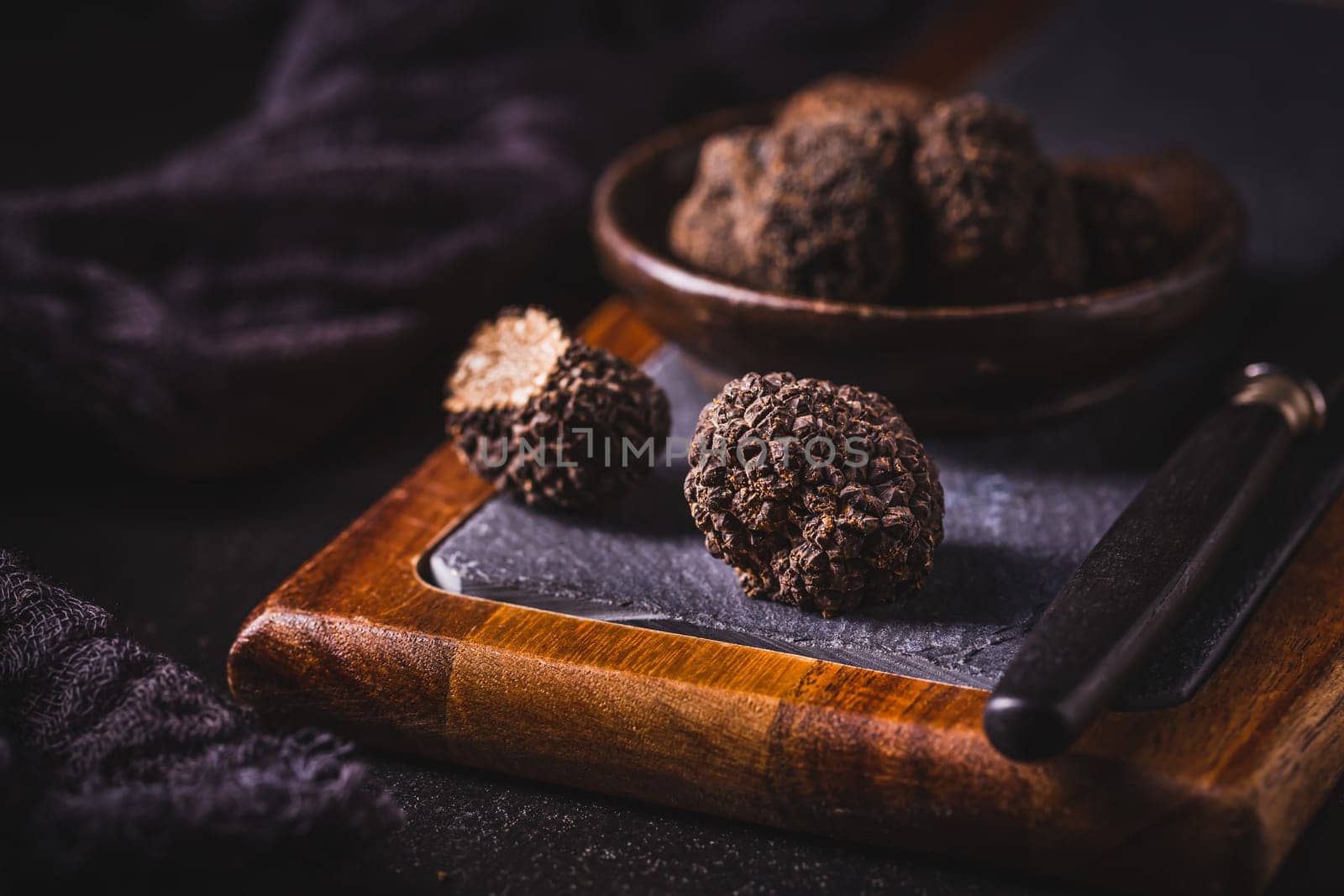 Expensive black truffles gourmet mushrooms  on kitchen table
