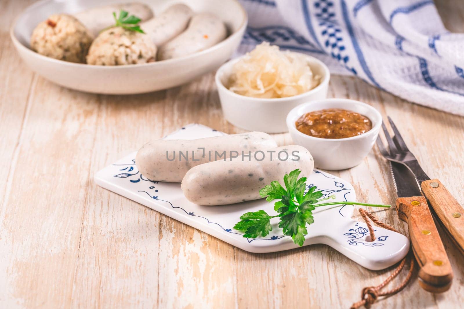 Bavarian white sausages with sauerkraut and bread dumplings, with mustard.