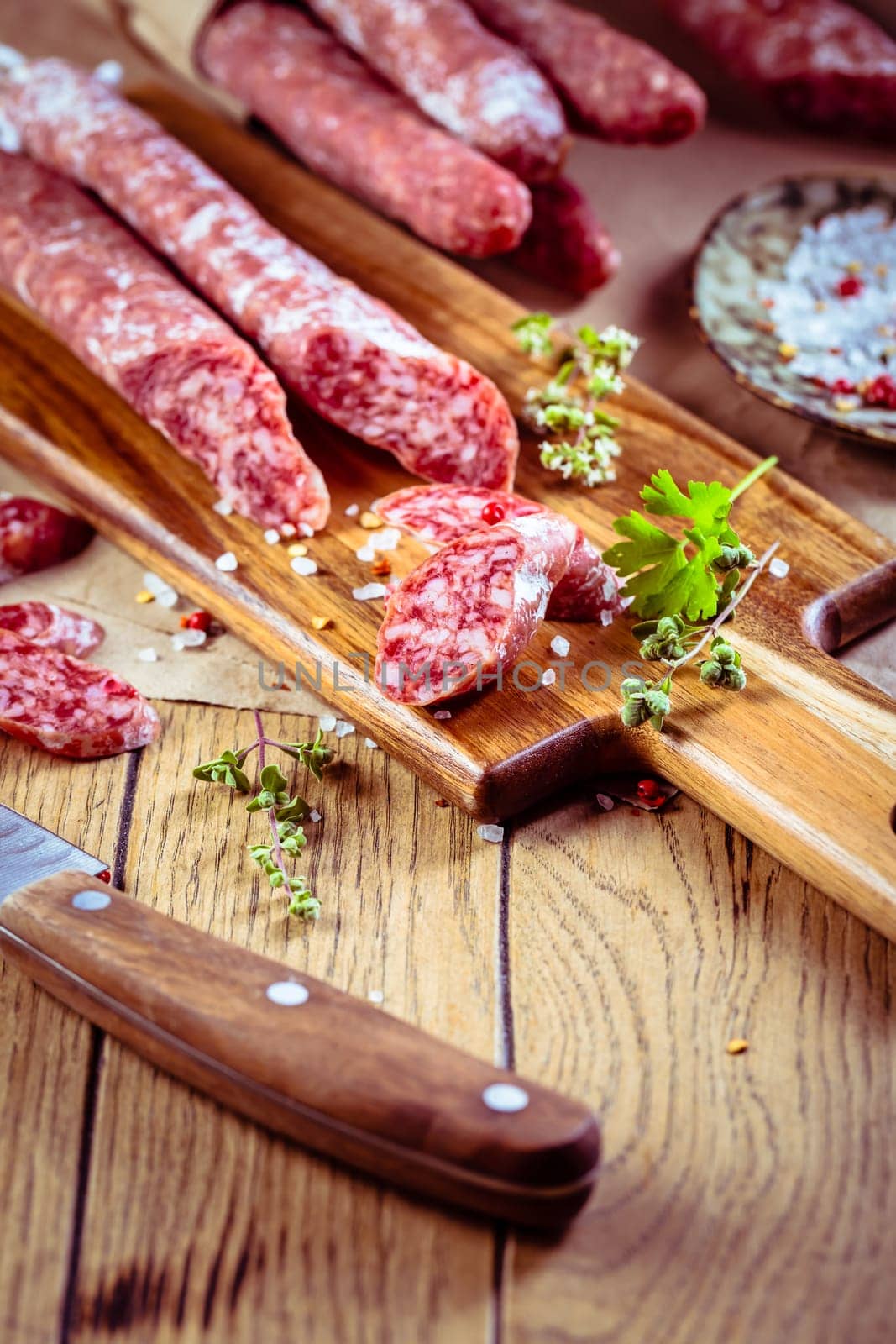 Traditional Spanish fuet on wooden background. Dry cured pork sausages with delicate taste.