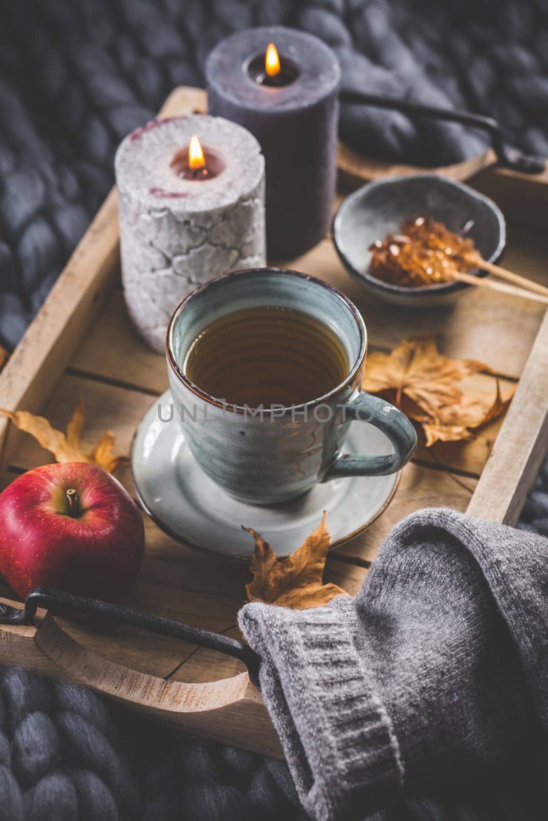 Autumn mood concept. Warm, cozy and rustic still life with cup of tea, candle and pumpkins.