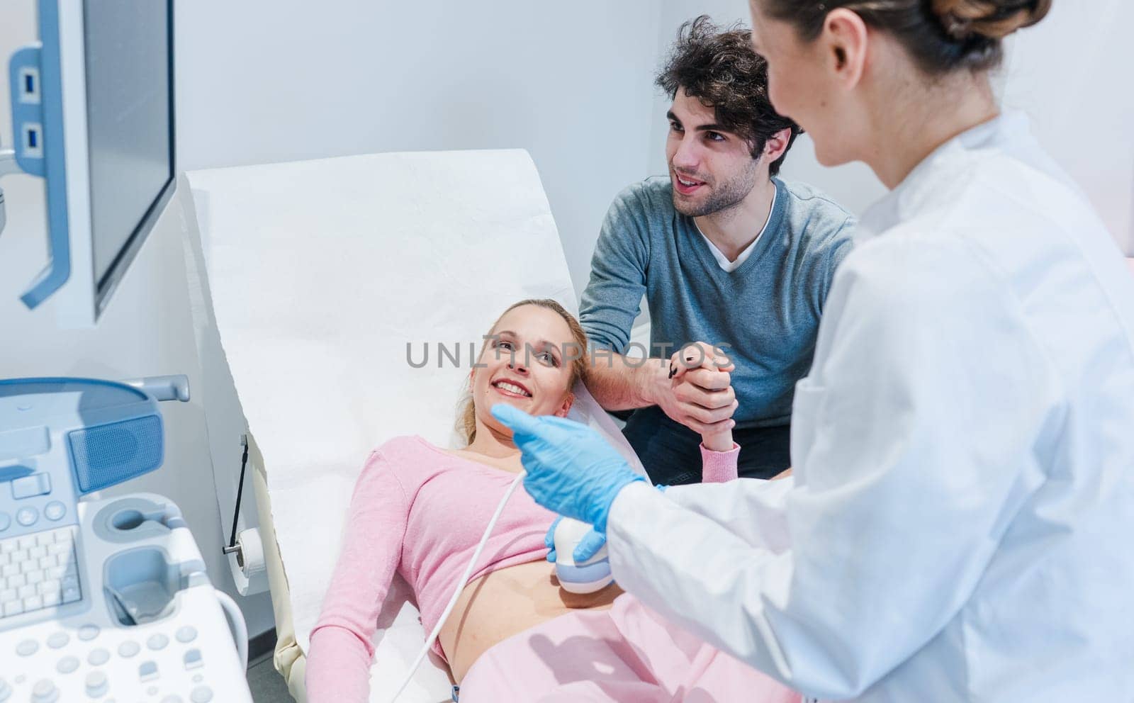 Couple in reproduction clinic being happy as the wife is pregnant as revealed by ultrasonic examination