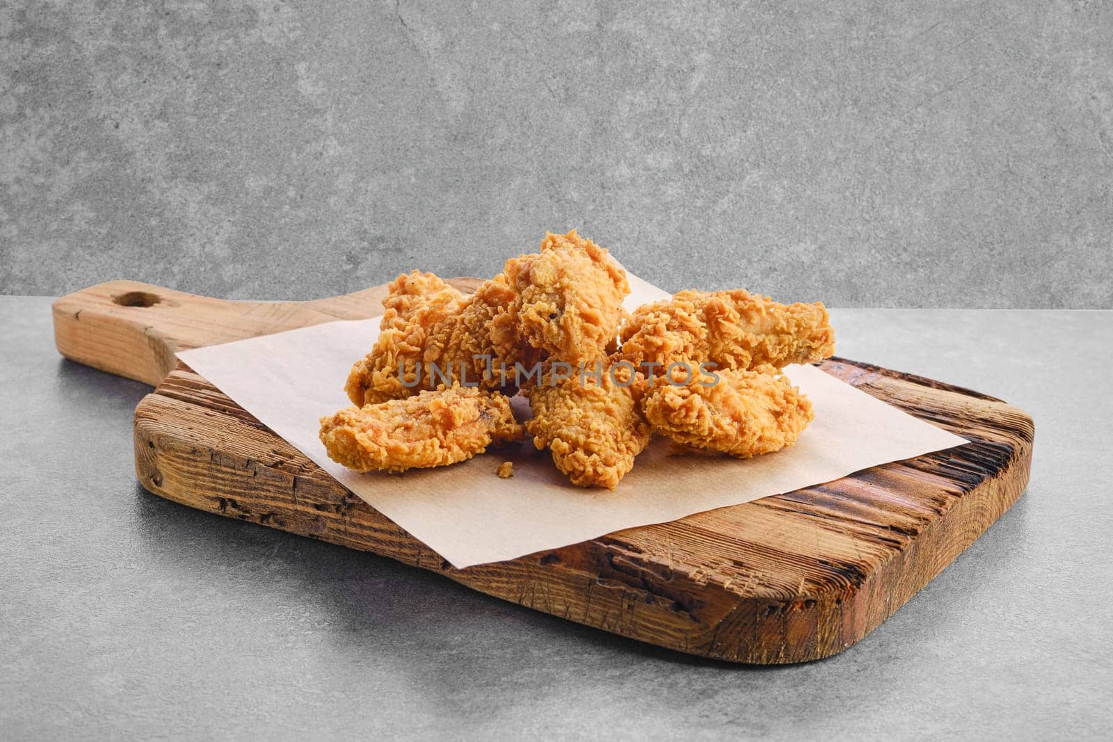 Deep fried chicken wings in breading on parchment paper