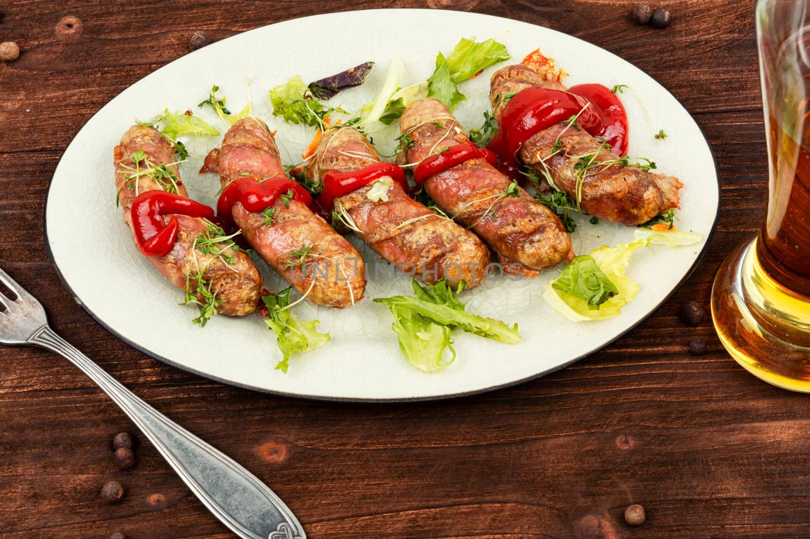 Roasted meat sausages on plate, fast food. Beer and bavarian sausages.