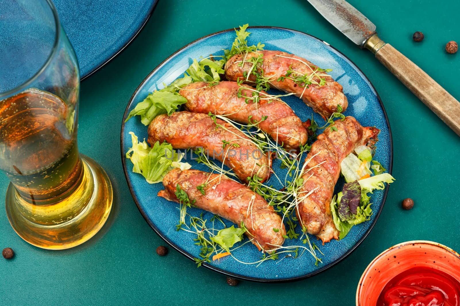 Roasted meat sausages on plate, fast food. Beer and bavarian sausages.