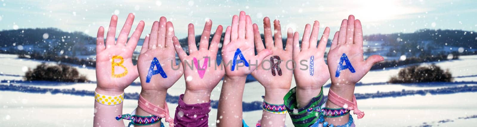 Children Hands Building Colorful English Word Bavaria. White Winter Background With Snowflakes And Snowy Landscape.