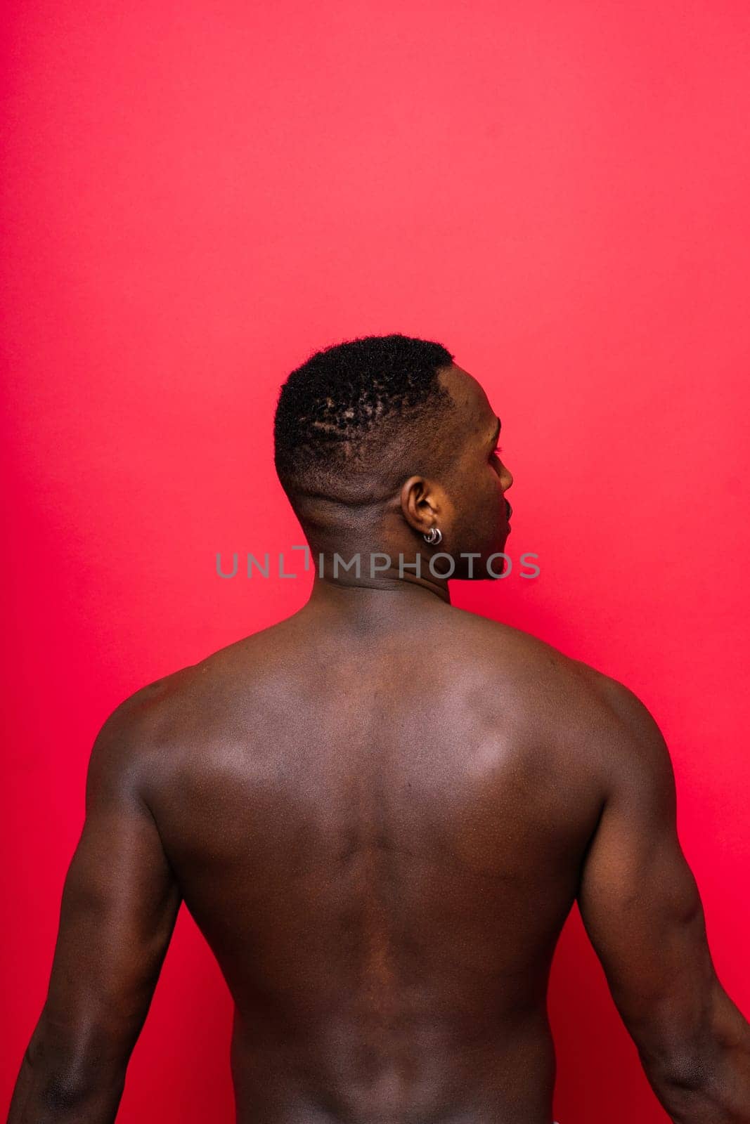 A handsome and muscular young man posing in a studio.