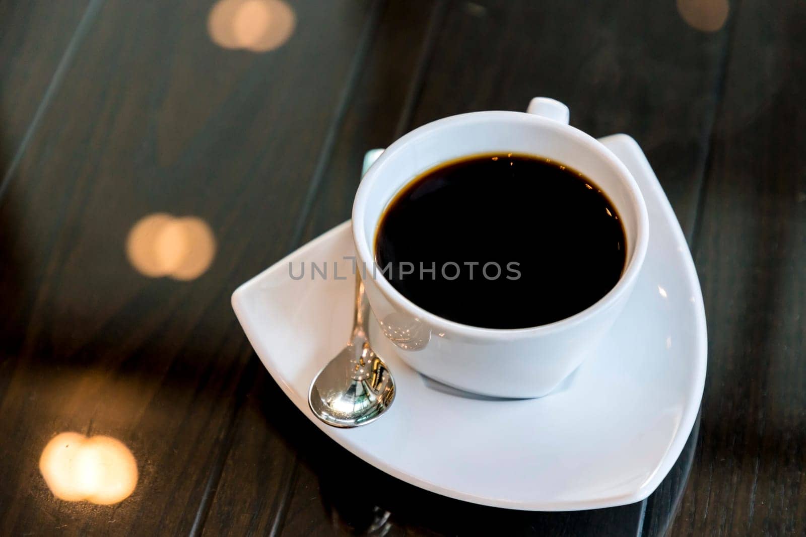 Black coffee in a white cup on a glass - top table. Selective focus.