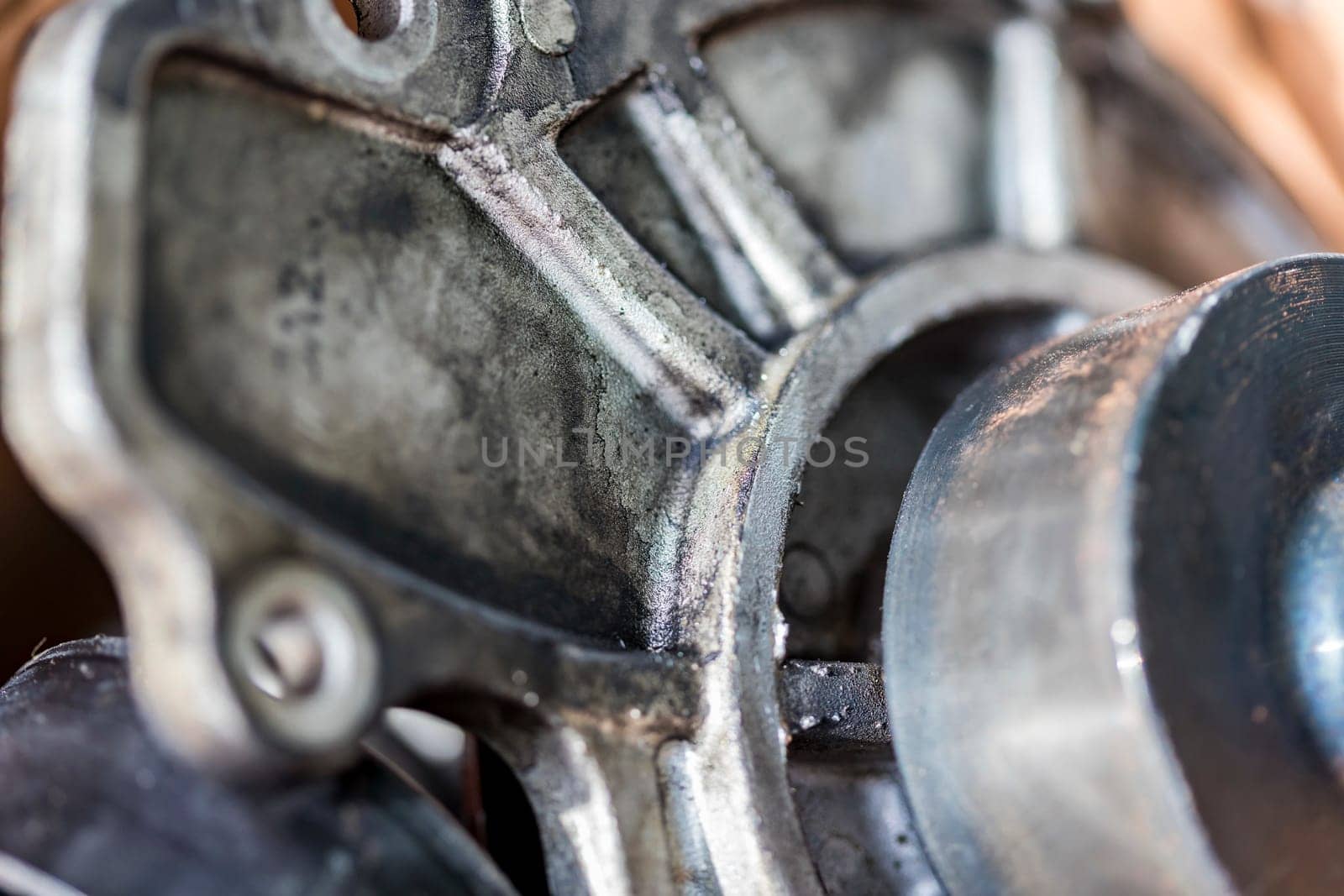 close up photo The focus is shallow, the mechanical parts are old. Black oil stains were firmly embedded on the surface. This shows that these parts have a long service life. no one cares.
